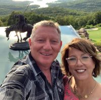 Couple smiling with scenic background view.